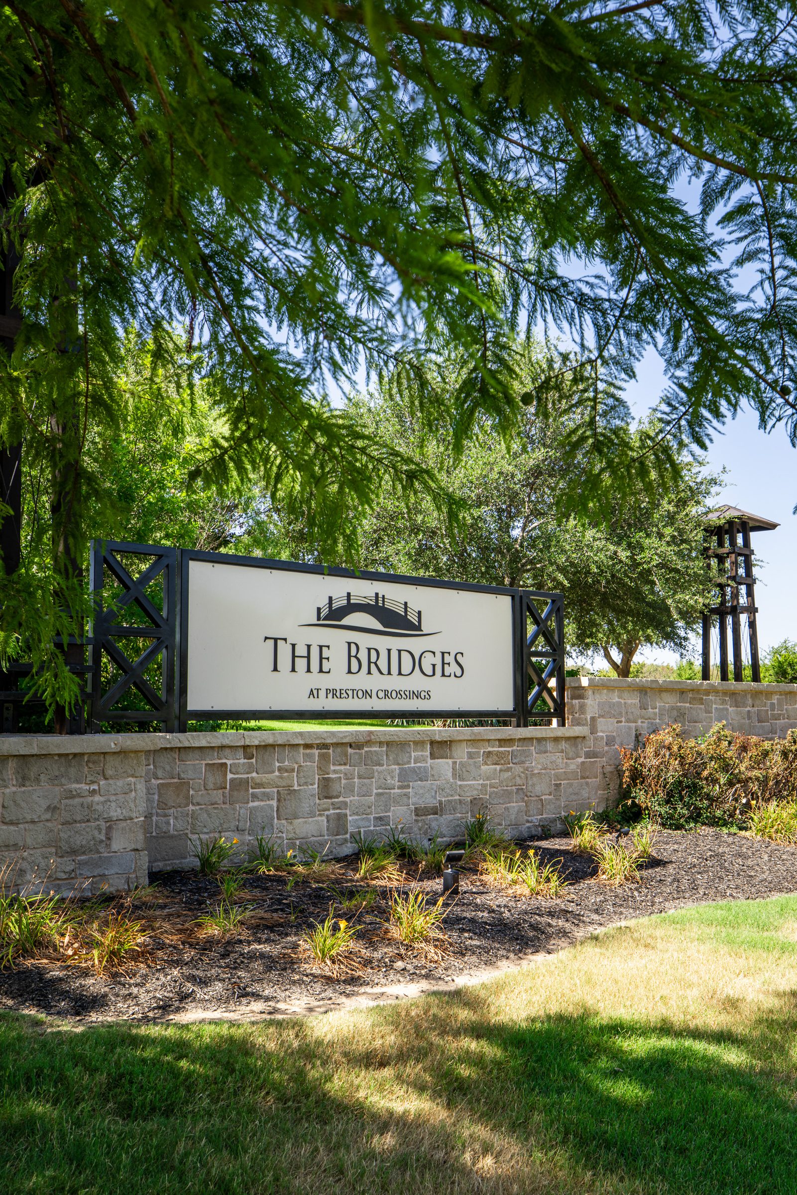 Stone-and-timber entrance monument for The Bridges at Preston Crossings in Gunter, Texas