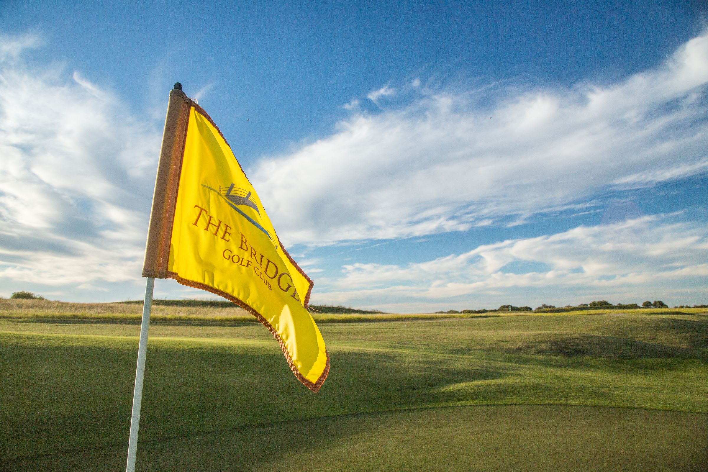 Yellow pin flag on the golf course at The Bridges
