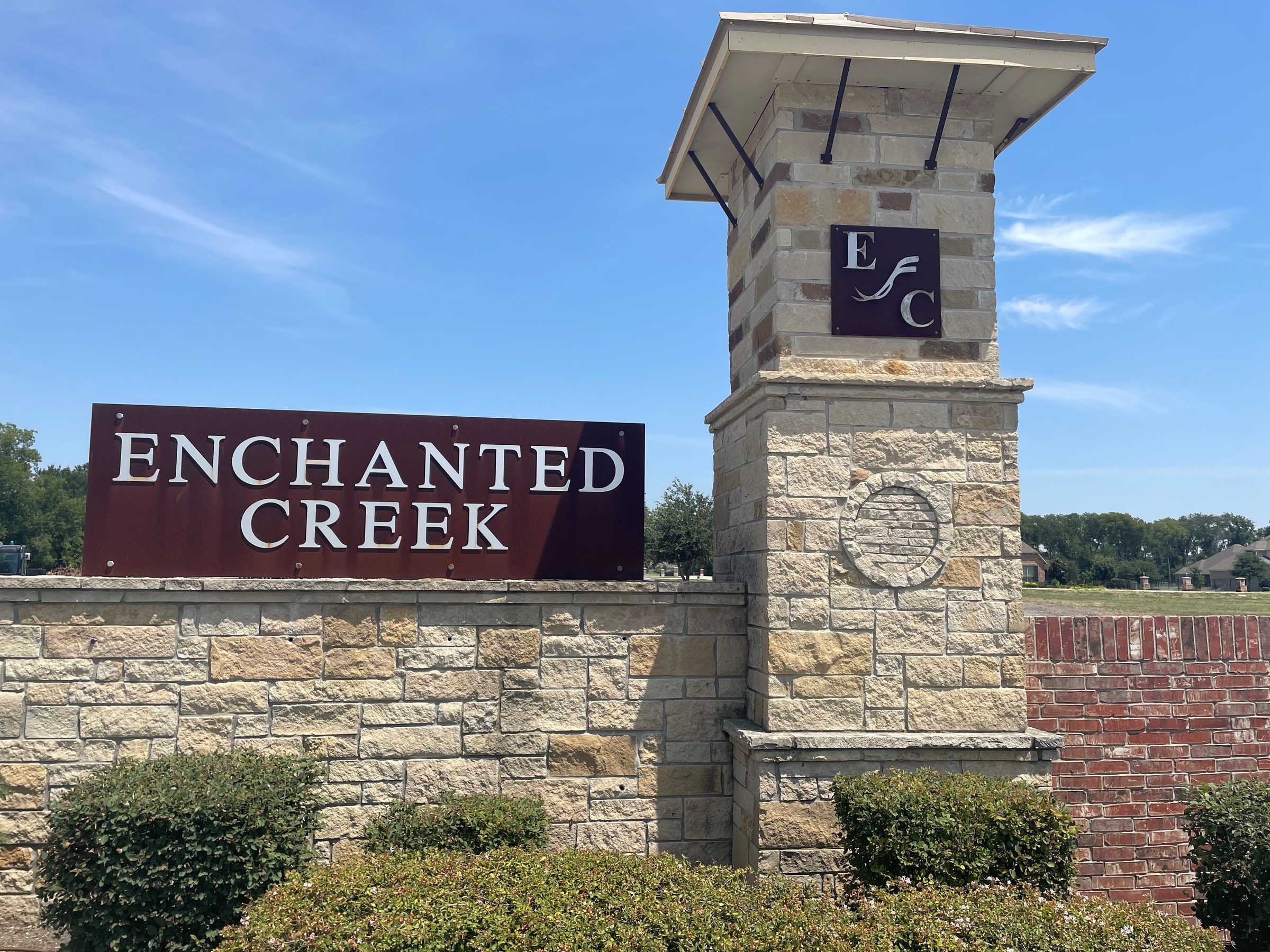 Enchanted Creek entrance monument — stone wall and tower with the community sign in Lucas, Texas