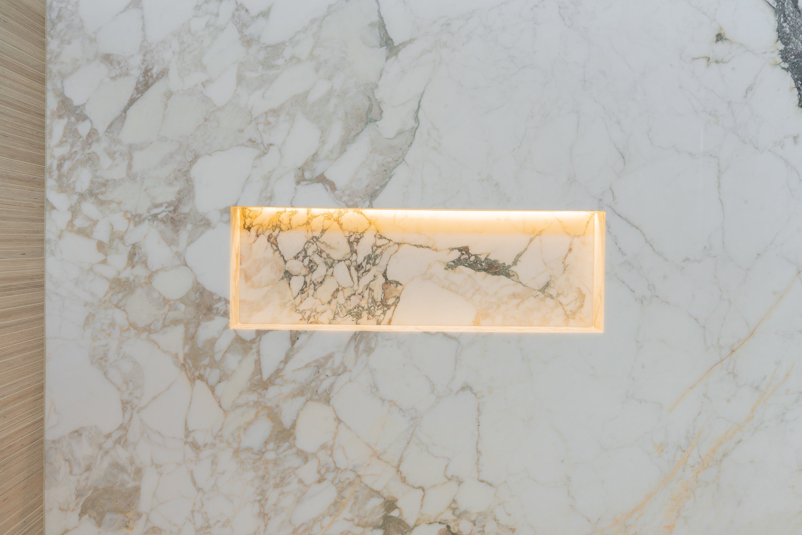 Detail of a book-matched natural stone slab used as a custom architectural accent